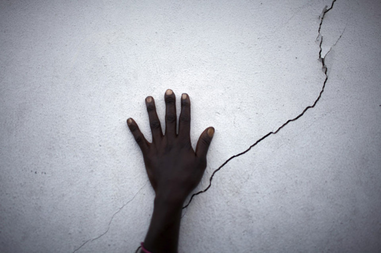 hand near a crack on a wall